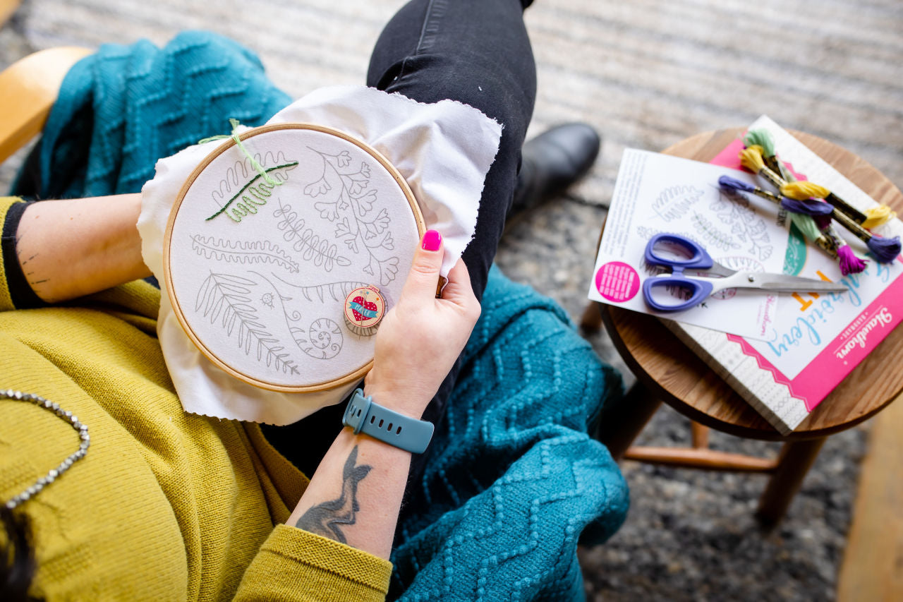 a woman stitching an embroidery hoop