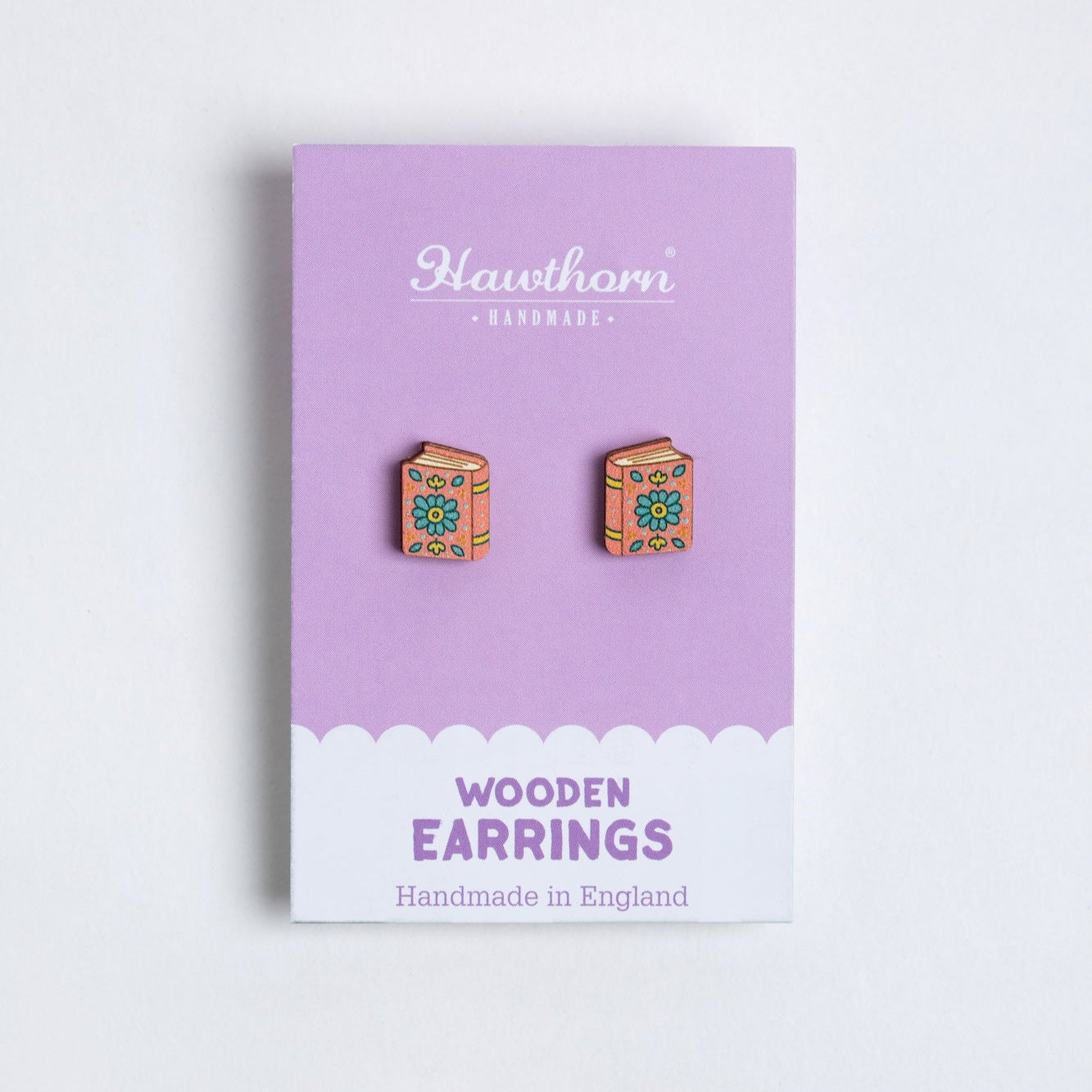 Book shaped Wooden earrings on a Hawthorn Handmade branded card with a purple background