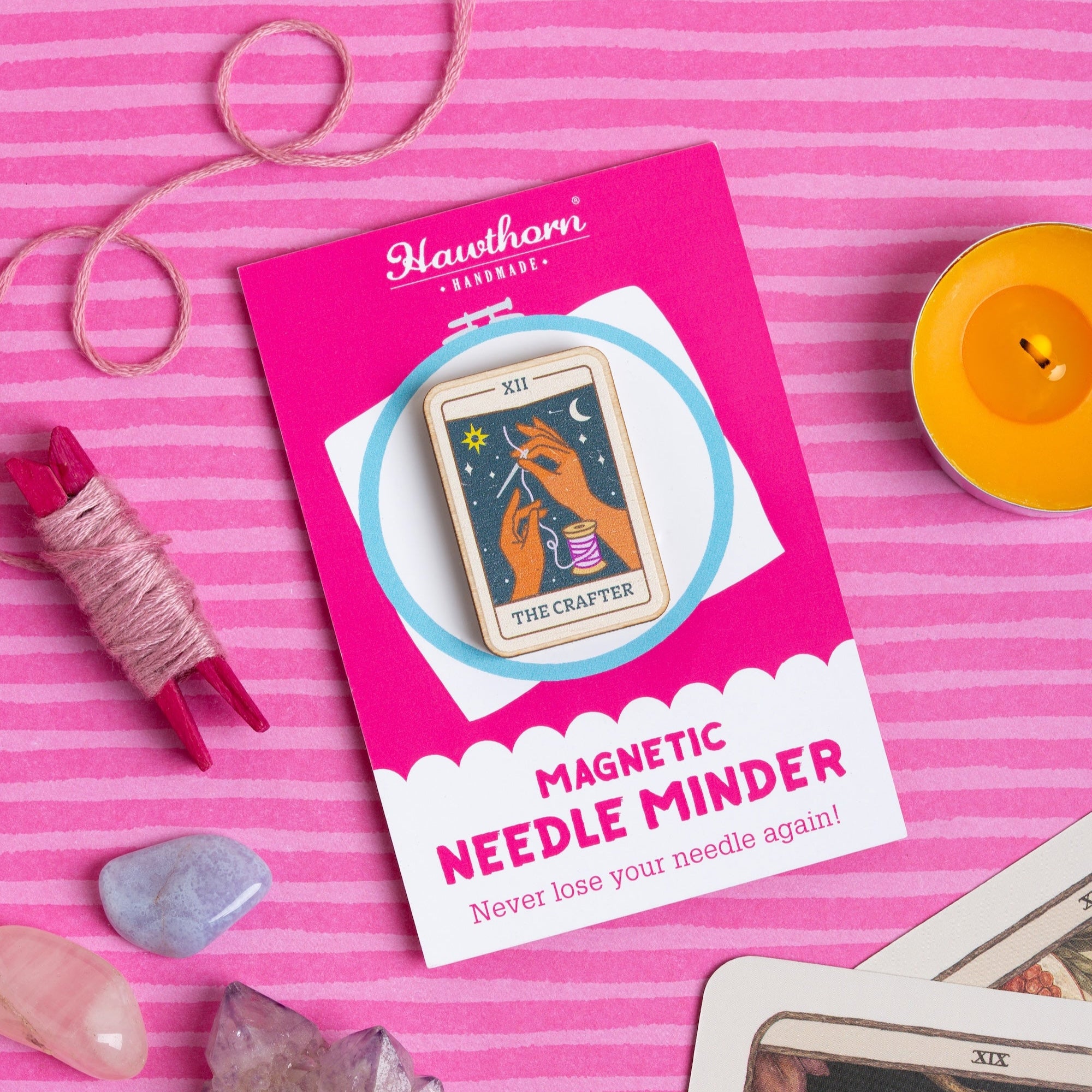 magnetic needle minder with tarot card design on a pink striped background