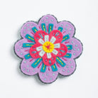 Clipped image of beatrix flower brooch on white background.