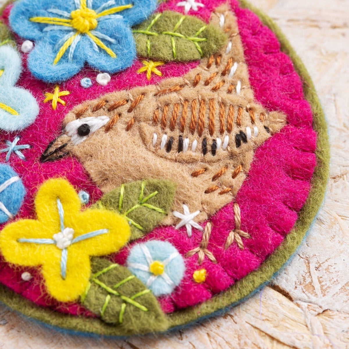 Close up image of wren brooch on wooden background.