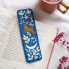 Decorative bookmark with a hare design on an open book next to a cup of tea.
