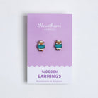 Pair of sheep wooden earrings on a purple card with 'Hawthorn' branding.