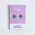 Pair of sheep wooden earrings on a purple card with 'Hawthorn' branding.