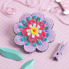 Beatrix Flower Brooch on purple background.