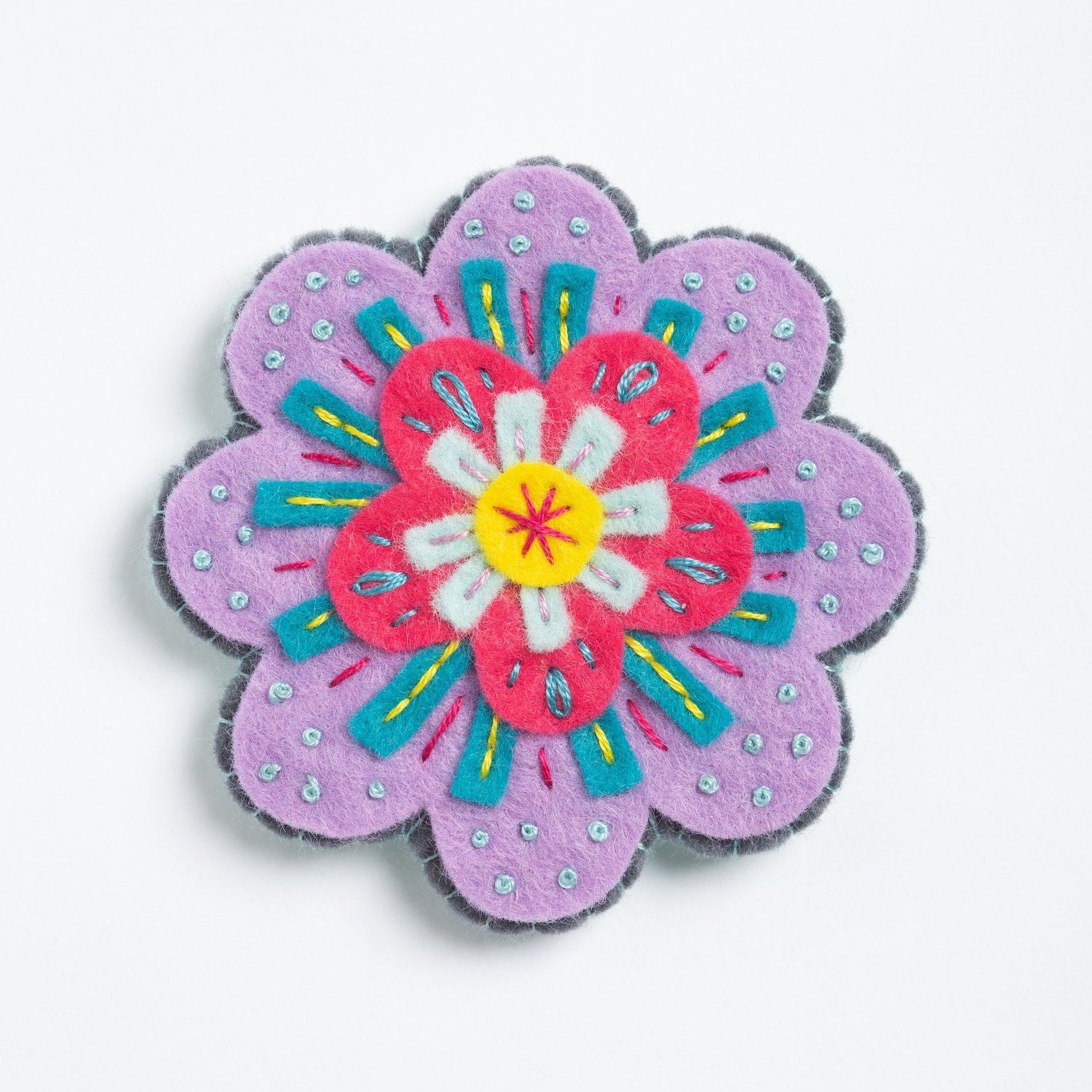 Clipped image of beatrix flower brooch on white background.