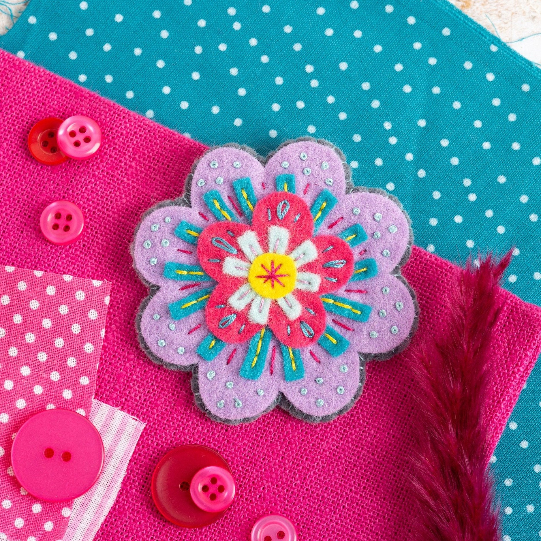 Beatrix flower brooch on colourful background.