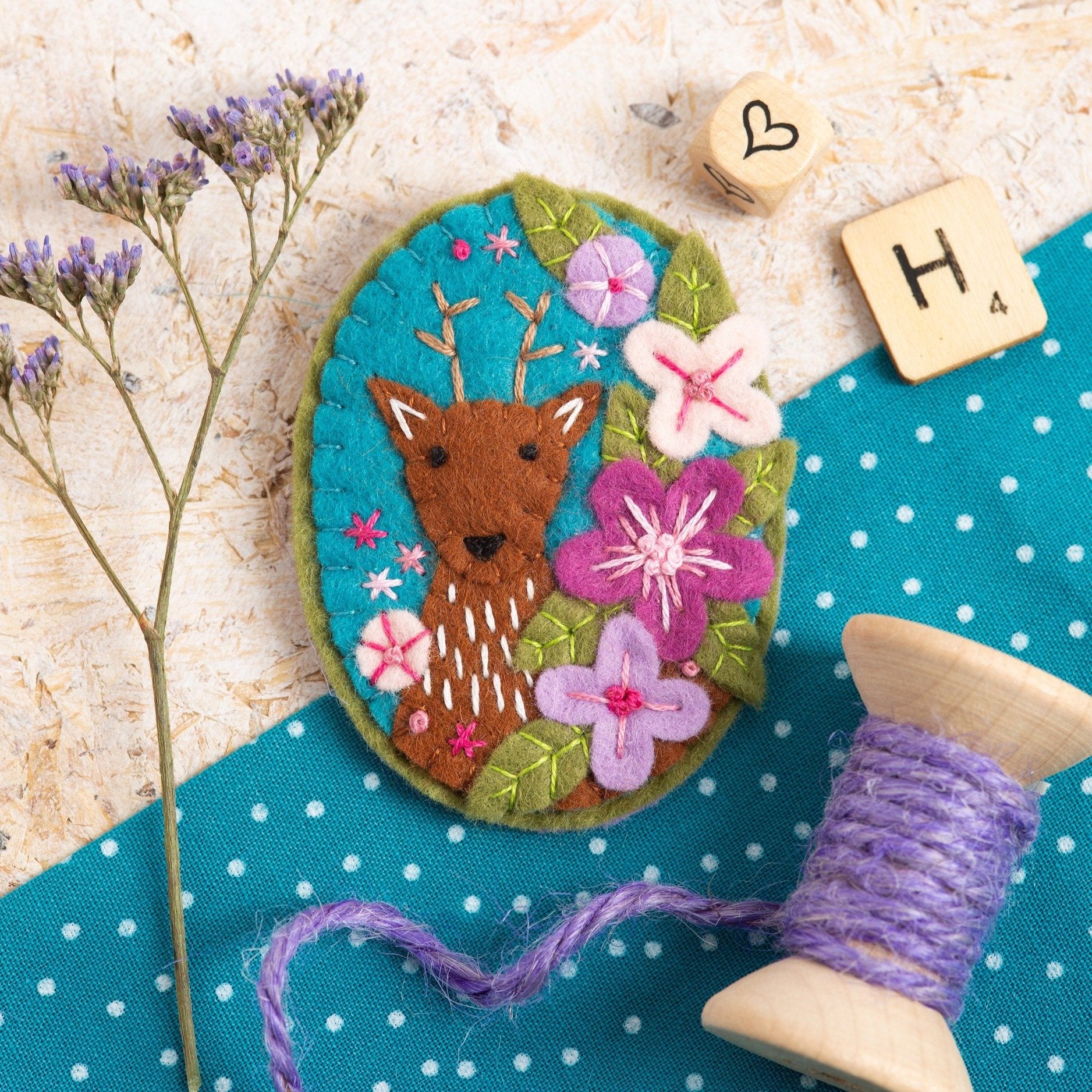 Deer brooch displayed on wooden background.