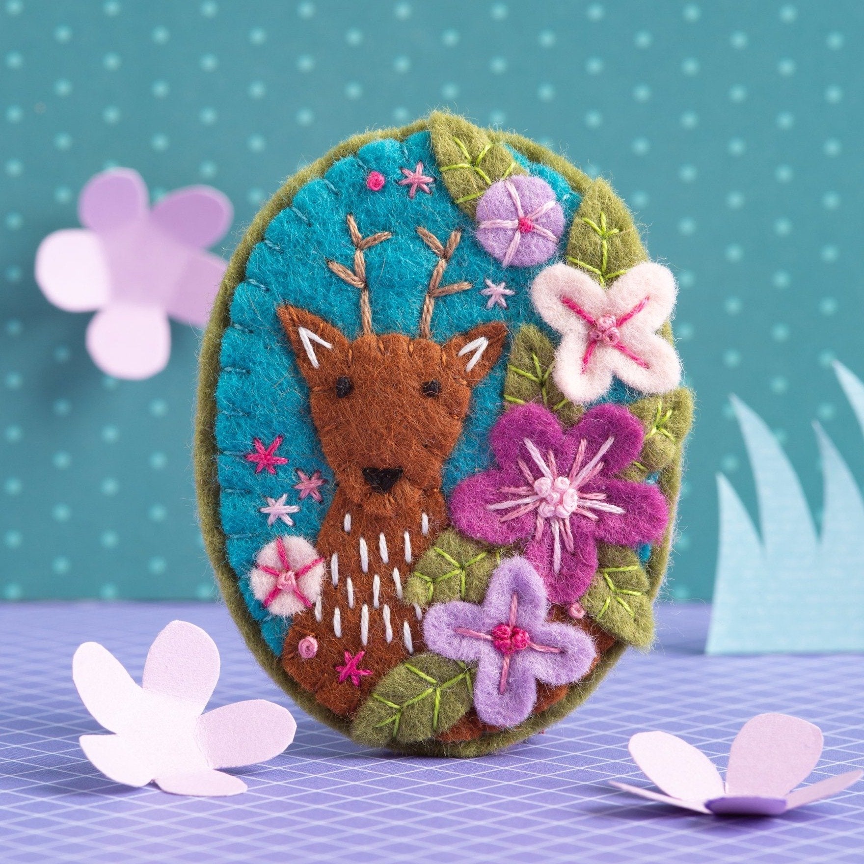 Deer felt brooch on colourful background.