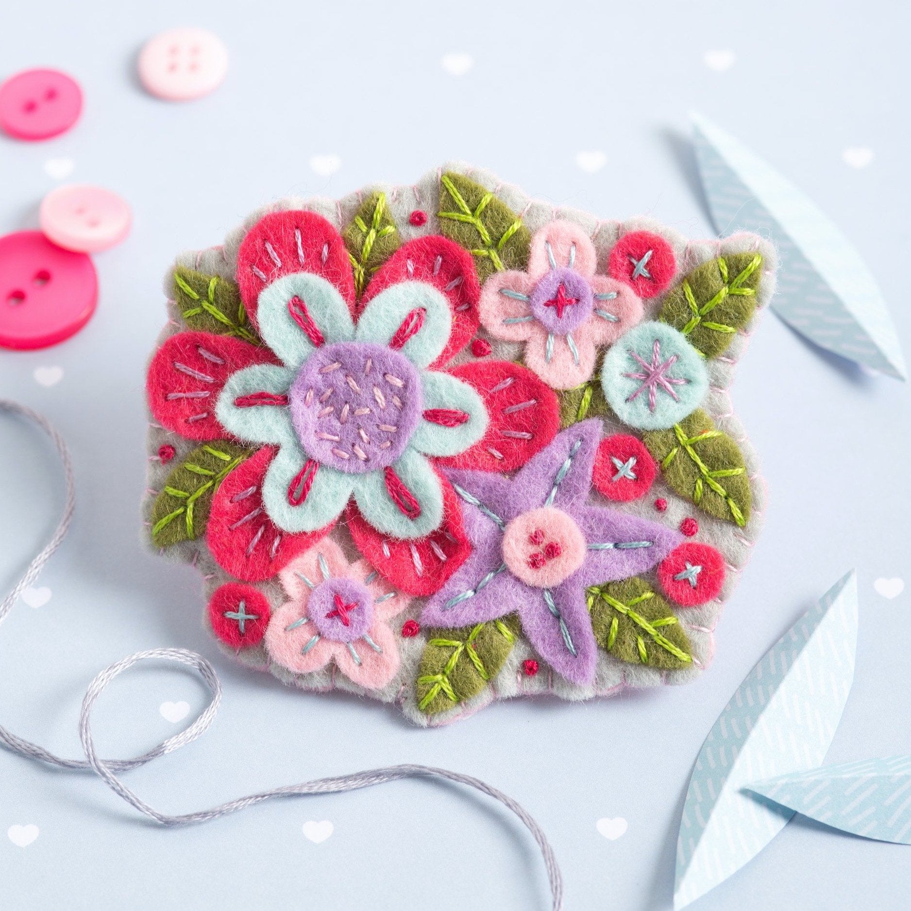 Gertrude flower brooch displayed on a pale blue background.