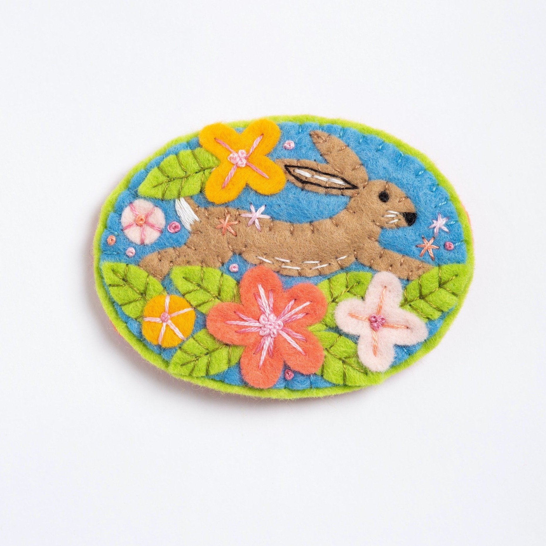 clipped image of hare felt craft brooch on white background.