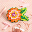 Margery Flower Brooch Felt Craft Kit on peach coloured background.