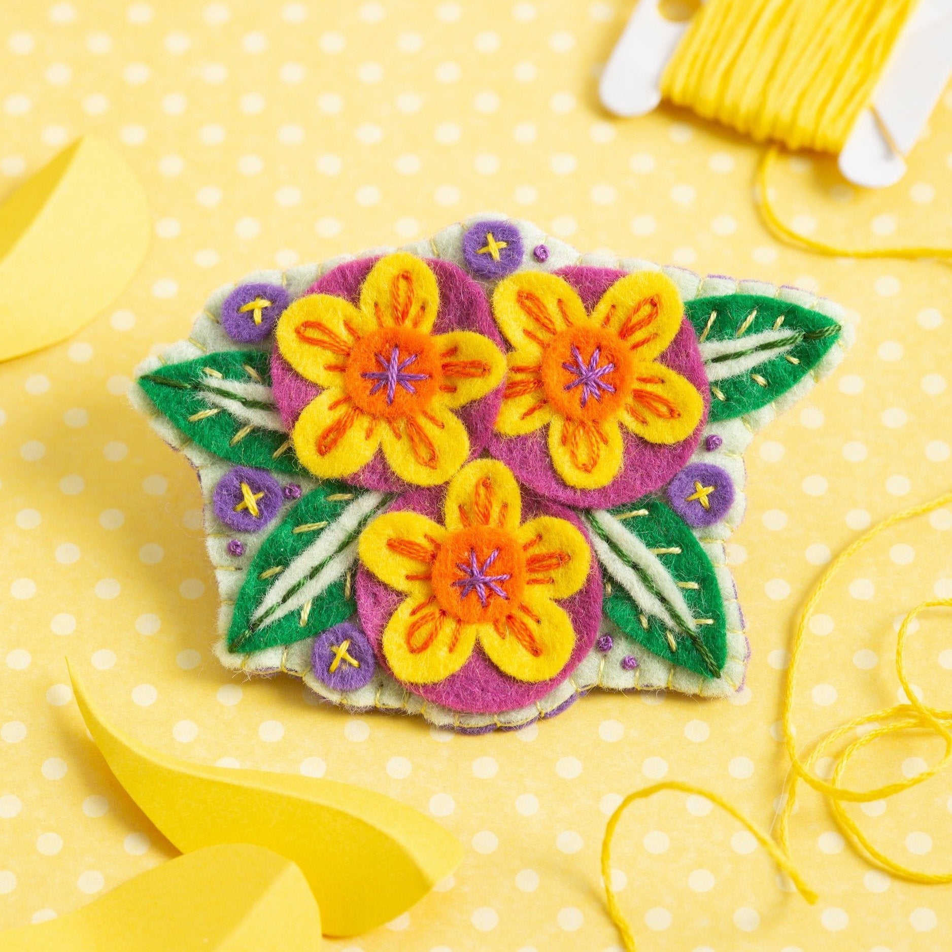 Penelope flower brooch felt craft kit on yellow polka dot background.