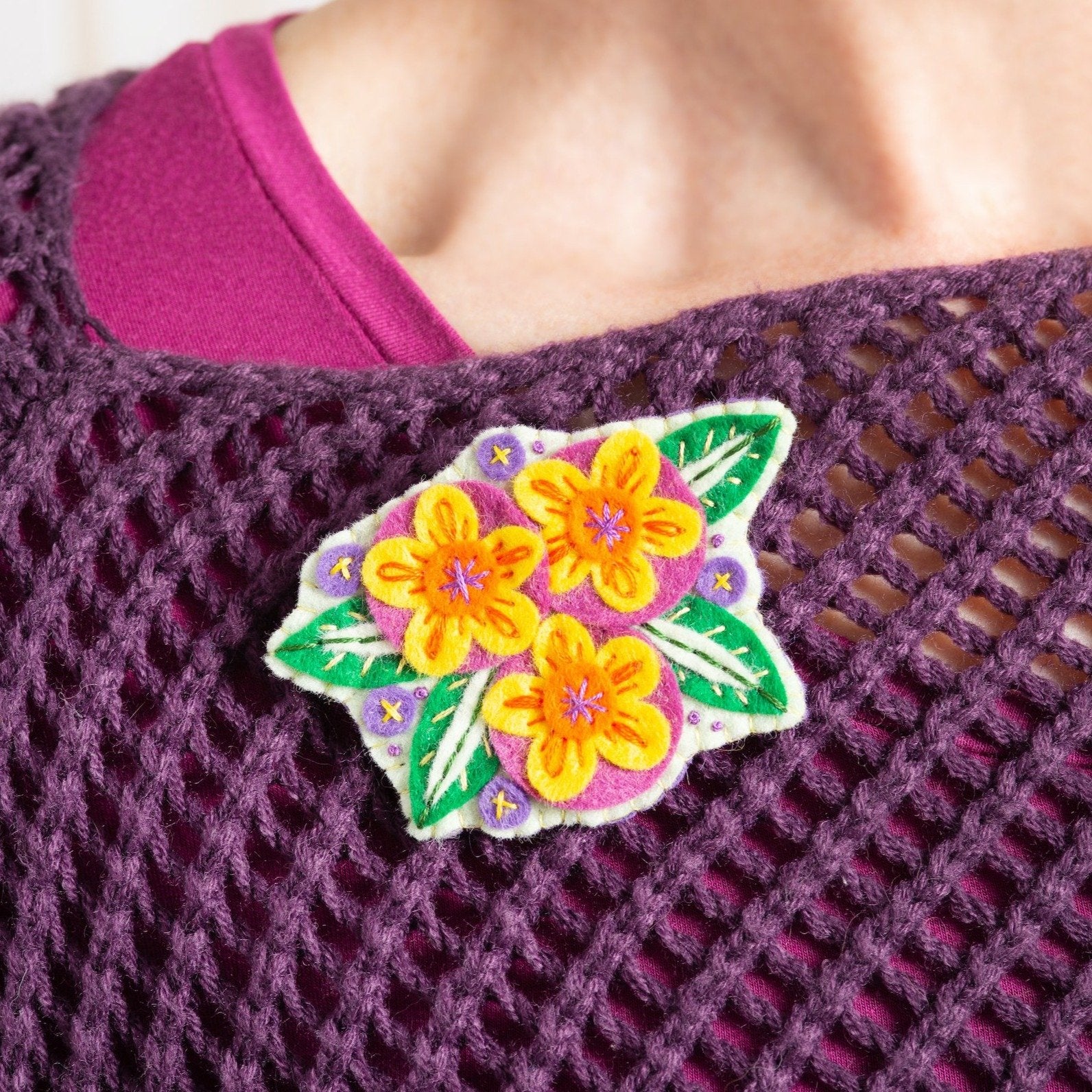 Penelope flower brooch worn on purple knitted jumper.