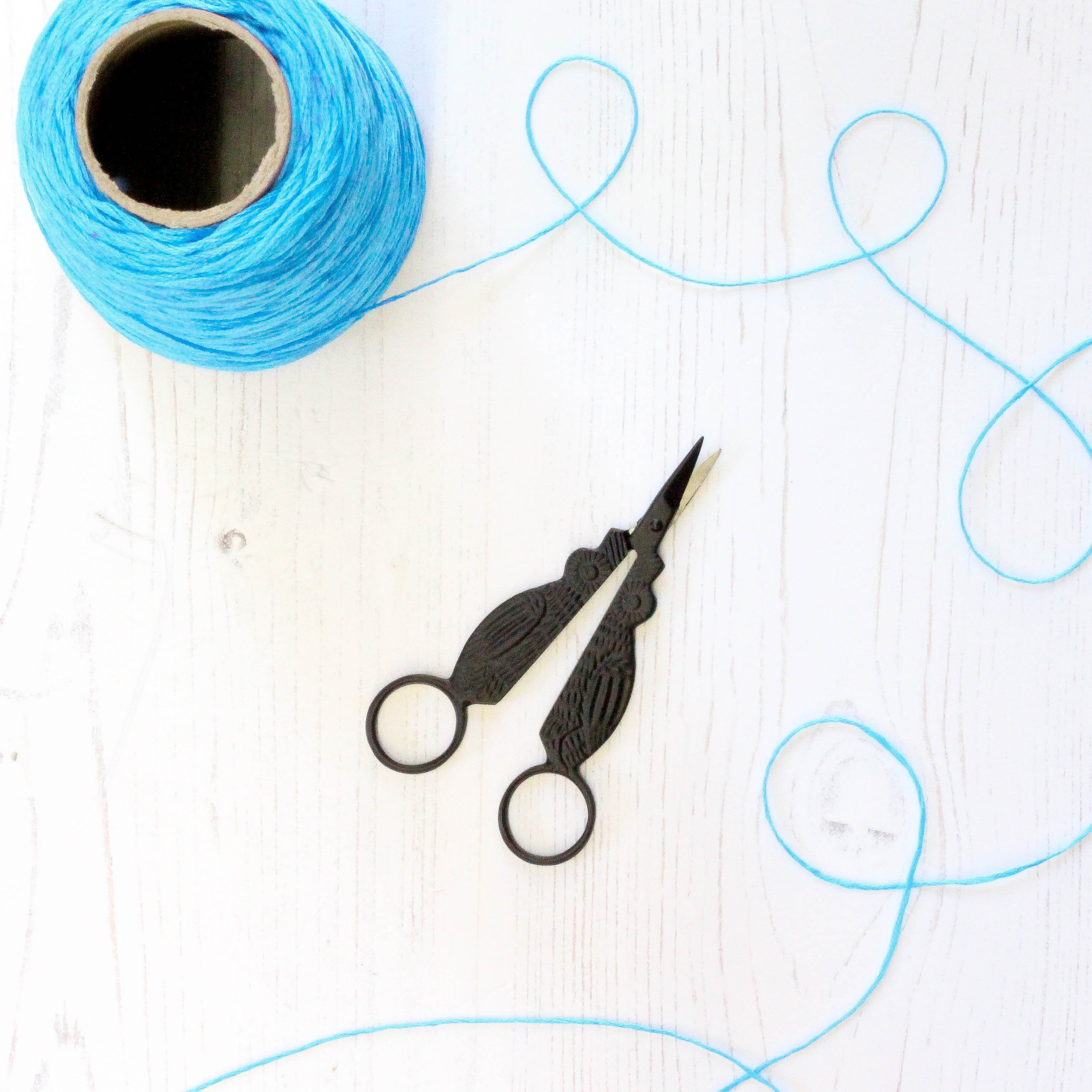 Black Owl Embroidery Scissors open with thread