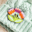 Marianne flower felt craft brooch won on mint green knitted hat.